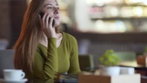 Die Attraktive Junge Frau Sitzt Einem Café Drinnen Und Telefoniert — Stockvideo