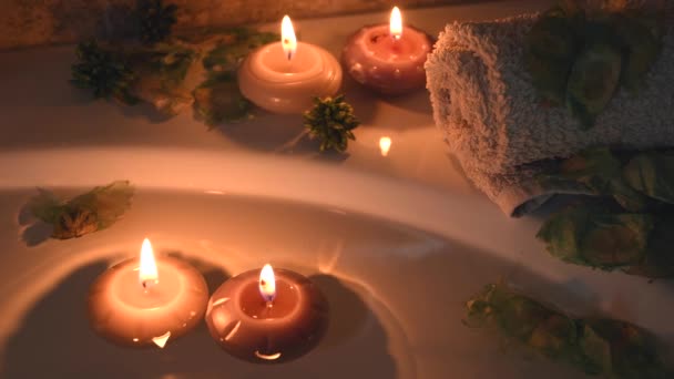 Relaxing Spa Background Candles Floating Bath Water Some Green Petals — Vídeo de stock