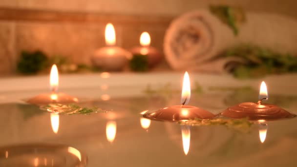 Relaxing Spa Background Candles Floating Bath Water Some Green Petals — Stockvideo