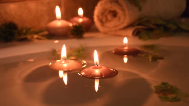 Relaxing Spa Background Candles Floating Bath Water Some Green Petals — Video