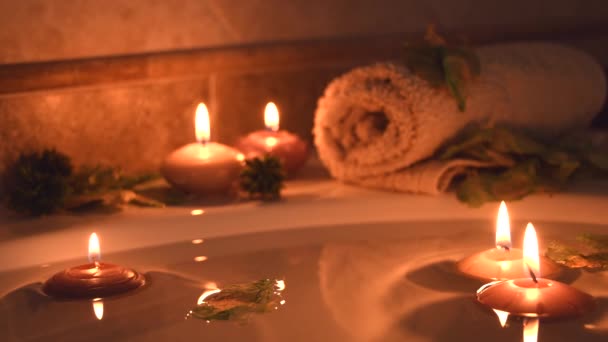 Relaxing Spa Background Candles Floating Bath Water Some Green Petals — Vídeo de stock