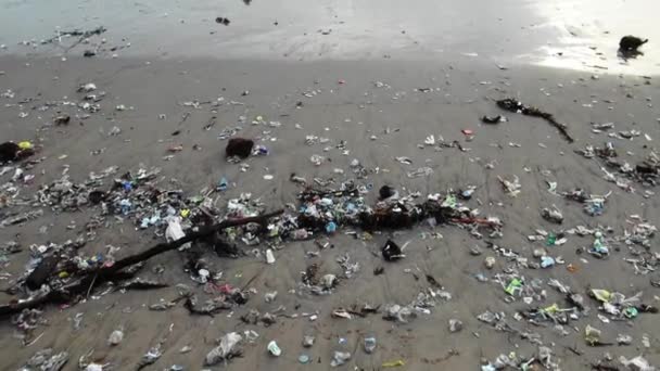 Tilt Shot Heavily Polluted Beach Ocean Waves Washing Trash Shore — Stock video