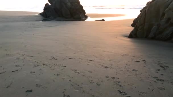 Two People Sitting Tall Rock Beach Bandon Oregon Enjoying Sunset – stockvideo