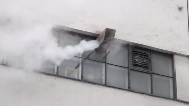 从带有小窗户的建筑物正面排气管冒出的白烟 — 图库视频影像