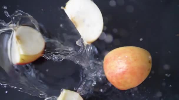 Fatias Frescas Maçã Vermelha Caindo Água Com Salpicado Filmado Câmera — Vídeo de Stock