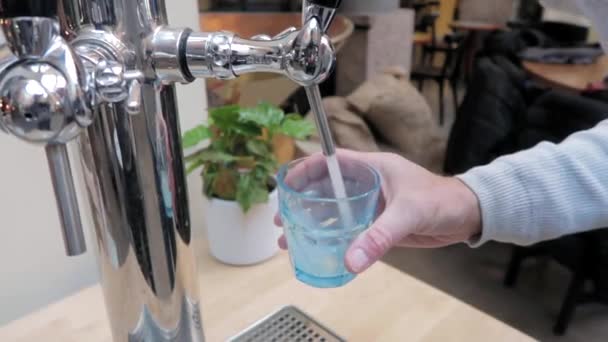 Man Giet Bruisend Water Uit Een Moderne Kraan Een Blauw — Stockvideo