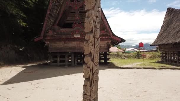 Drone Stijgt Met Een Totempaal Voorgrond Bij Traditionele Batak Huizen — Stockvideo