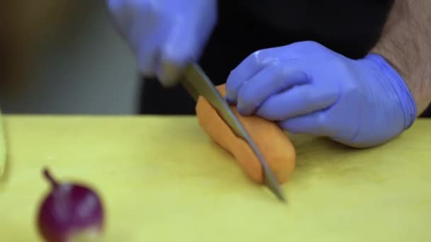 烹饪过程中的近距离镜头 戴着手套的炊事器将红辣椒和胡萝卜片放在木板上 并将其添加到油锅中 又是一片蔬菜 — 图库视频影像