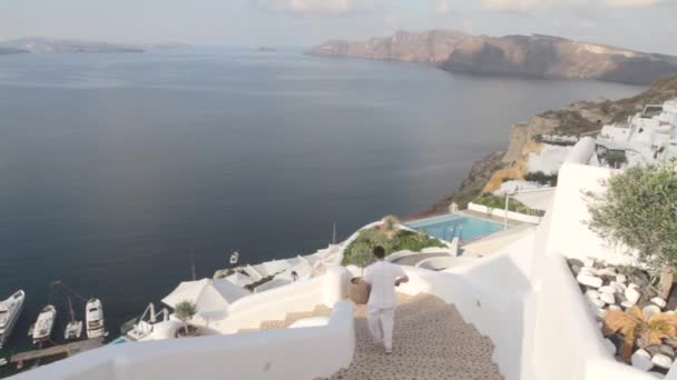 Mężczyzna Biegnie Schodach Świeżym Powietrzu Uliczce Greckiej Wiosce Oia Santorini — Wideo stockowe