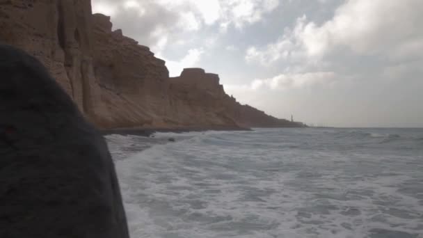 Vagues Frappant Une Plage Sable Noir Entourée Formations Falaises Volcaniques — Video