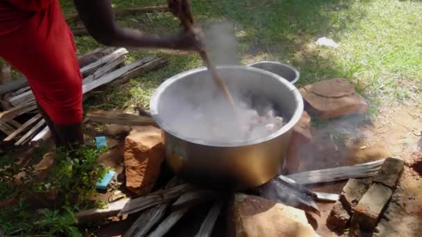 Wanita Afrika Mengaduk Besar Pot Daging Atas Kayu Api — Stok Video