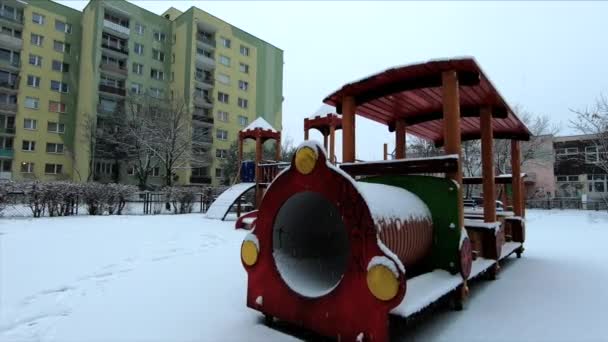 雪は街の小さな遊び場に落ちています スローモーショントラッキングショット — ストック動画