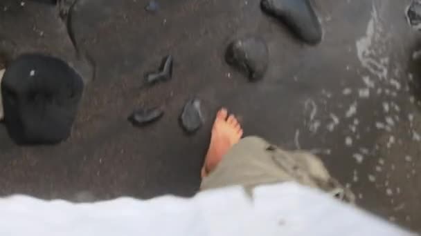 Vista Hombre Caminando Descalzo Una Playa Arena Negra Con Olas — Vídeo de stock