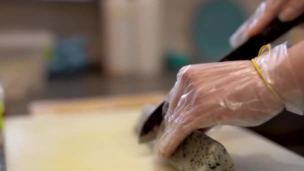 料理人による寿司作りの密着動画 彼はほとんど料理の準備をしている 三角形の寿司ロールを真ん中にカットし キッチンナプキンで彼のナイフをきれいにした後 — ストック動画