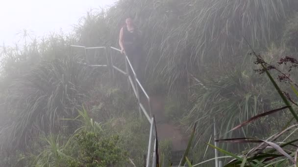 Young Woman Walks Cloud High Haiku Stairs — стоковое видео