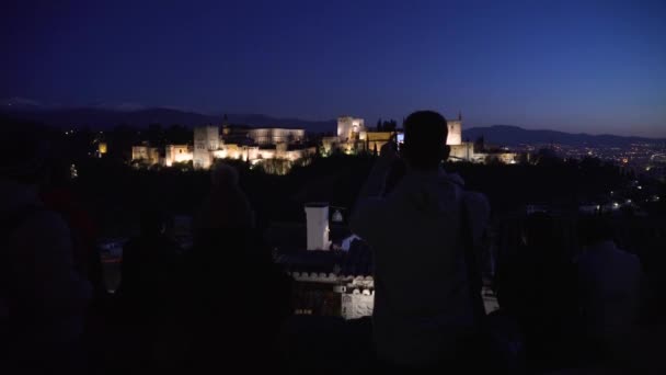 夕日の後にアルハンブラ宮殿の写真を撮る観光客のシルエット — ストック動画