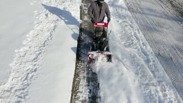 Camera Pans Show Man Using Snow Blower — стоковое видео