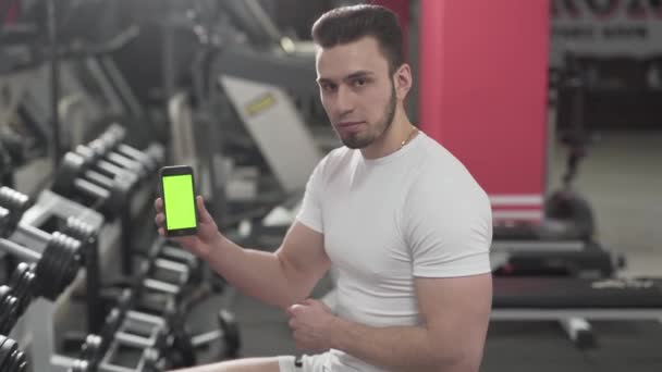 Trener Fitness Siedzi Pobliżu Sprzętu Siłowni Naciska Coś Telefon Pokazuje — Wideo stockowe