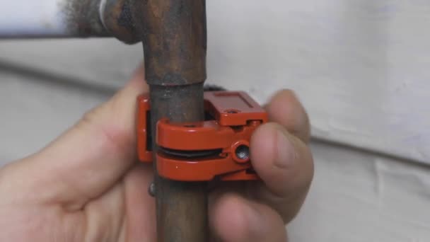 Male Hands Turn Orange Pipe Cutter Open Old Copper Pipe — ストック動画