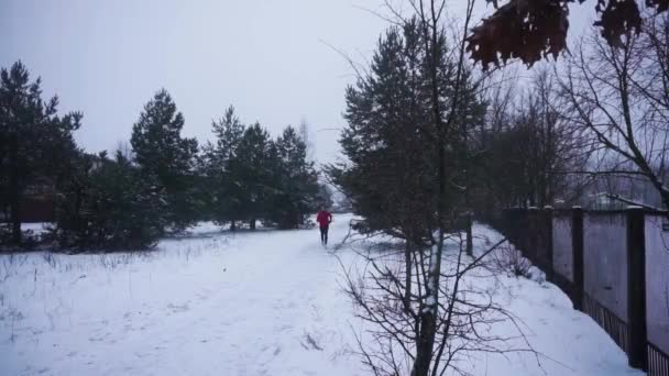 Junger Mann Mit Rotem Kapuzenpulli Und Schwarzer Hose Läuft Winter — Stockvideo