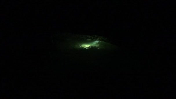 跳水者从一个又长又冷的洞穴跳水返回到入口 — 图库视频影像