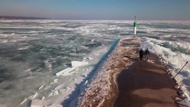 Пара Держащихся Руки Идет Доку Замерзшем Озере Маяку Наклон Дрона — стоковое видео
