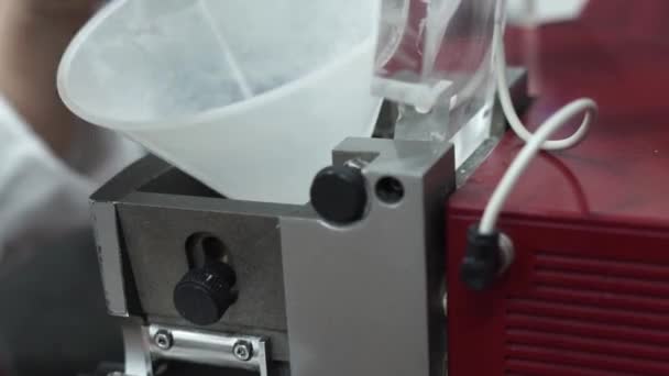 질높은 테스트를 기계에 밀가루를 추가하기 깔때기를 사용하는 실험실 기술자의 — 비디오
