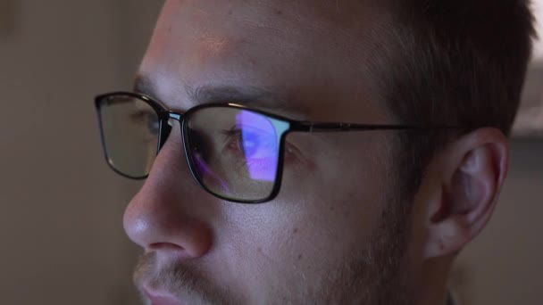 Großaufnahme Eines Mannes Mit Blaulichtbrille Der Auf Den Bildschirm Blickt — Stockvideo