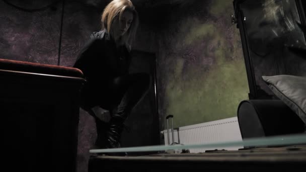 Тёмной Мрачной Комнате Молодая Женщина Снимает Ботинки Плюхается Диван Подбирает — стоковое видео