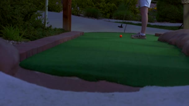 Una Chica Caucásica Mini Golf Una Pelota Golf Naranja Golpeando — Vídeo de stock