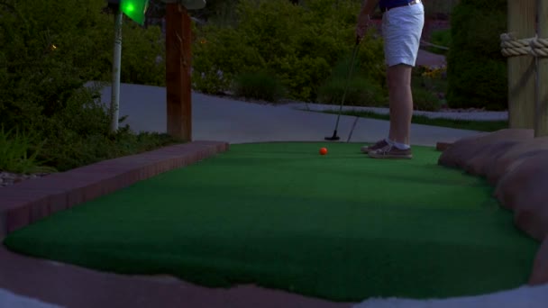 Een Blank Meisje Minigolf Een Oranje Golfbal Raakt Het Naar — Stockvideo