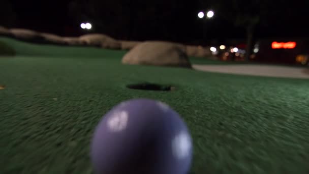 Purple Mini Golf Ball Falls Golf Hole Bounces Pocket Course — Stock Video