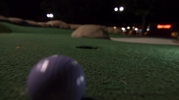 Mor Bir Mini Golf Topu Golf Deliğine Düşer Bir Sahada — Stok video