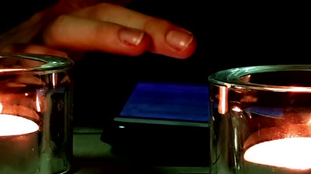 Nahaufnahme Brennende Kerzen Fokus Und Das Smartphone Hintergrund Frau Verfolgt — Stockvideo