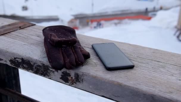 在佐治亚州古杜里滑雪度假村 冬季降雪时 手机和手套落在木栏杆上 慢速Zoom — 图库视频影像