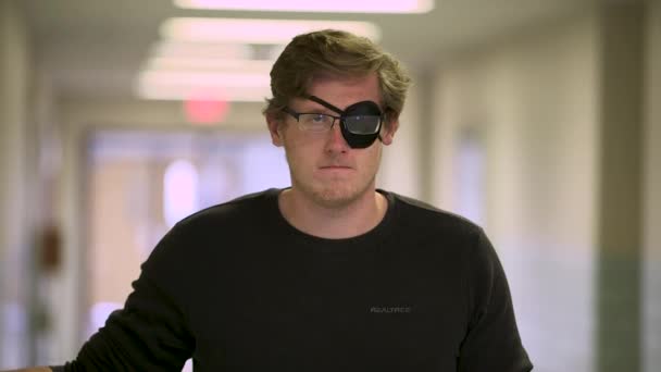 White Man Eye Patch Glasses Stares Camera Seriously Hallway — Stock Video