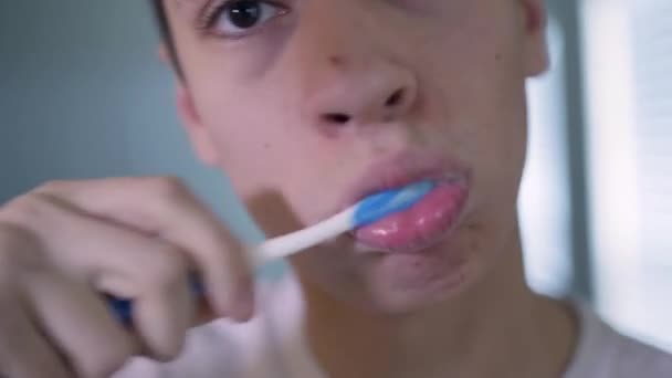 Young Caucasian Man Brushes Teeth Looking Straight Camera Close — стокове відео