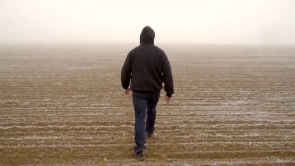 Caucasian Male Hoodie Walking Alone Arid Field Mysterious Thick Fog — Stockvideo