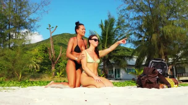 Attractive Women Swimsuit Sitting White Sand Massaging Bodies Sunscreen Exotic — Stockvideo
