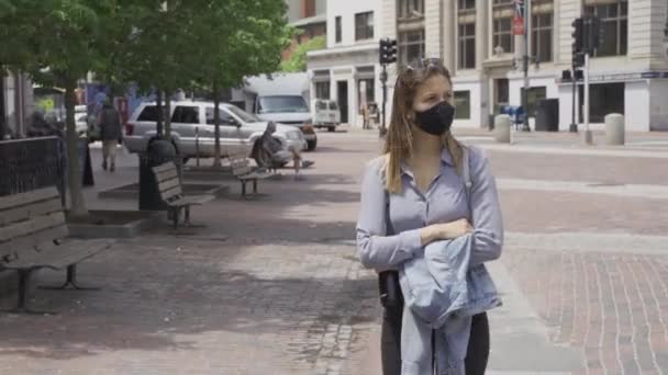 女の子はコロナ大流行の間 黒い保護マスクで歩道を一人で歩く — ストック動画