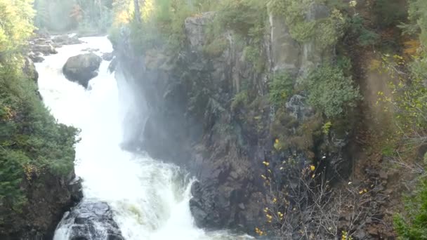 岩の多い地形で霧と空気の流れを作成する強力な劇的な滝 — ストック動画