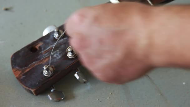 古いジャンキーギターから古い弦を取り除き — ストック動画
