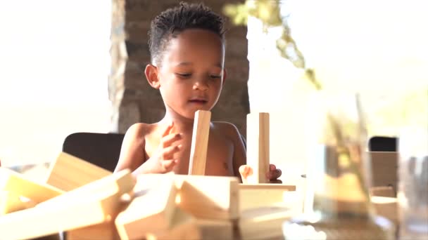 Kis Dél Afrikai Fiú Egyensúlyozó Blokkok Asztalon — Stock videók