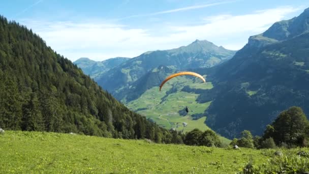 Gleitschirmflieger Fliegt Den Schweizer Alpen Den Berg Hinunter — Stockvideo