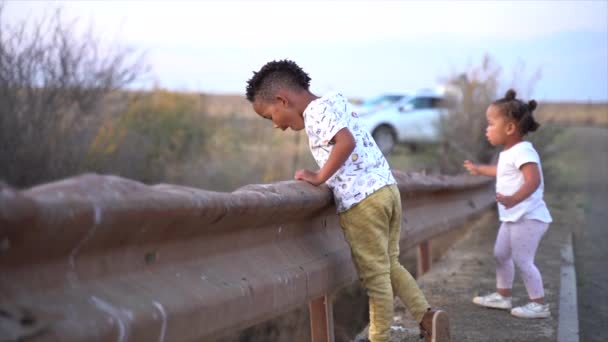 南アフリカの男の子と女の子オンA Low Bridgeで冬の国の風景に夕暮れ — ストック動画