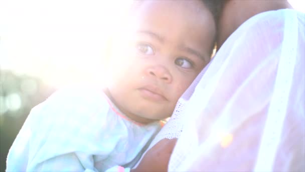 南非小女孩躺在妈妈腿上 身后有太阳的近照 — 图库视频影像