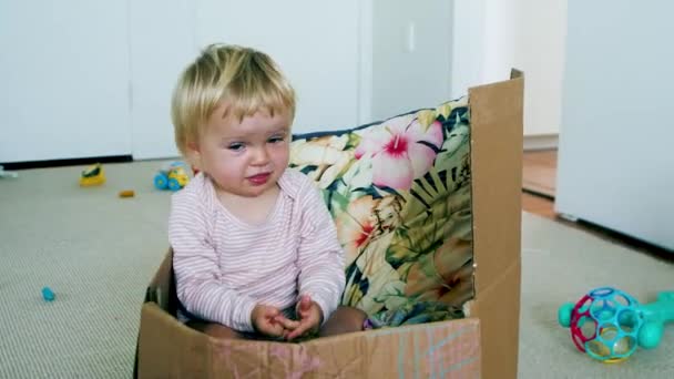 Liten Toddler Sitter Inne Kartong Boxning Fylld Med Kuddar Gunga — Stockvideo