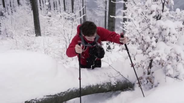 Νεαρός Πεζοπόρος Πεζοπορικούς Πόλους Σκαρφαλώνοντας Πάνω Από Χιονισμένο Ξύλινο Κορμό — Αρχείο Βίντεο
