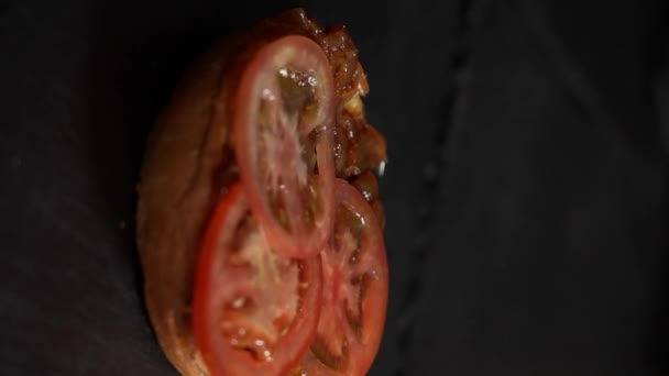 番茄慢动作地掉在汉堡包上 垂直射击 — 图库视频影像