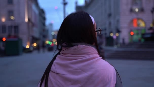 英国ロンドンのピカデリー サーカスで夕暮れ時の若い女性に続いて クローズアップ — ストック動画